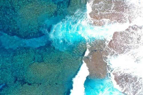 現場空中写真(北西側領域のサンゴ礁:水深が浅くなった場所で砕波が見られる)